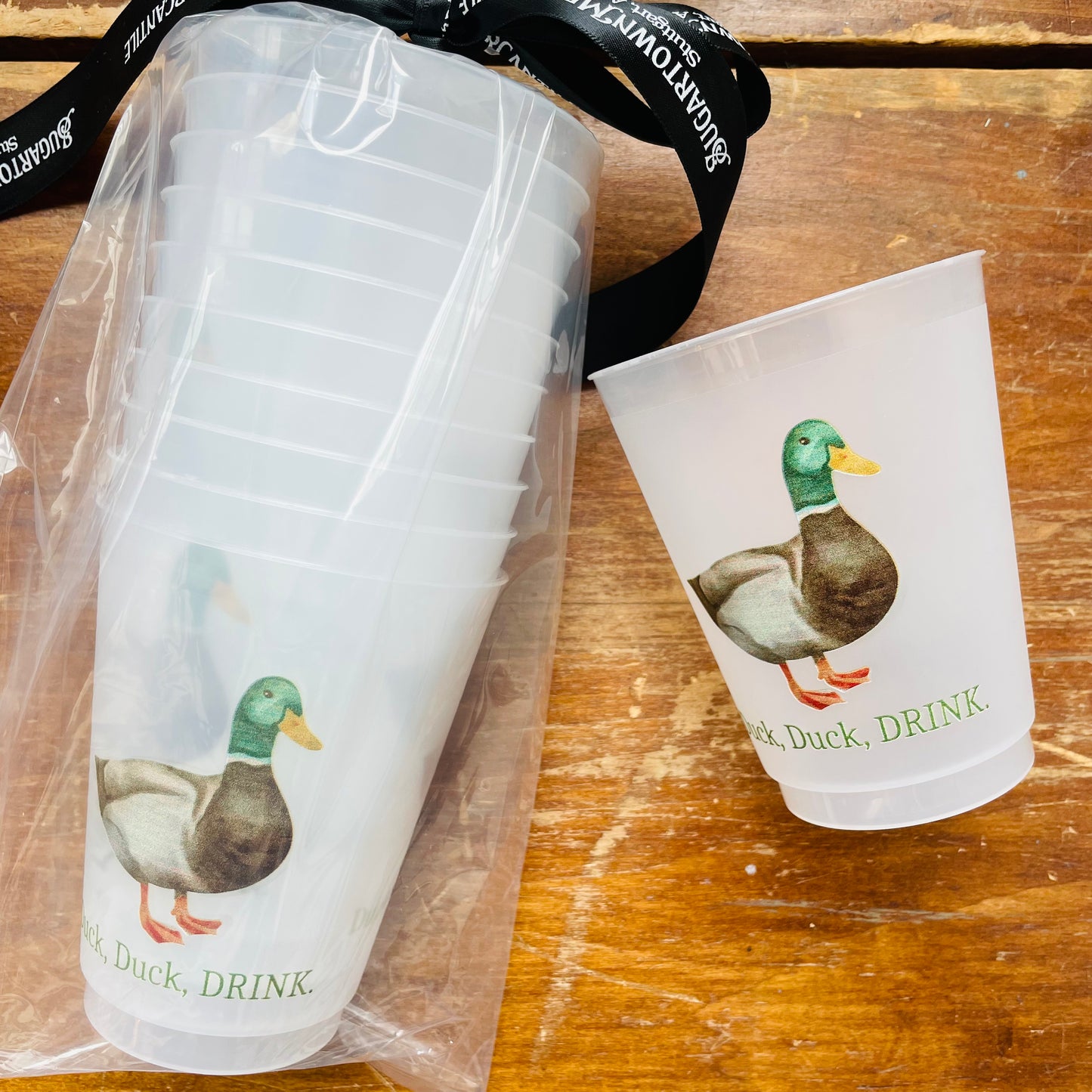 A set of frosted white plastic cups with a mallard drake illustration and the text 'Duck, Duck, DRINK'.
